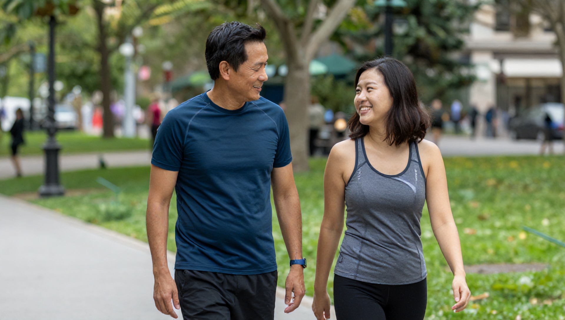 Duas pessoas sorrindo e conversando enquanto caminham em um parque, demonstrando o 'teste da conversa' da Zona 2